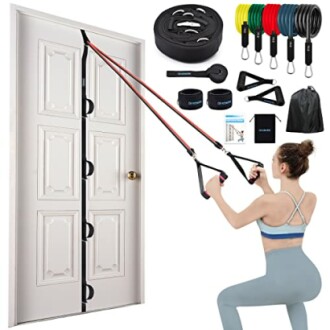 Woman using door anchor resistance bands set with various accessories.