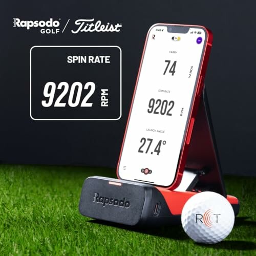 Rapsodo golf device measuring spin rate with smartphone and golf ball on grass.